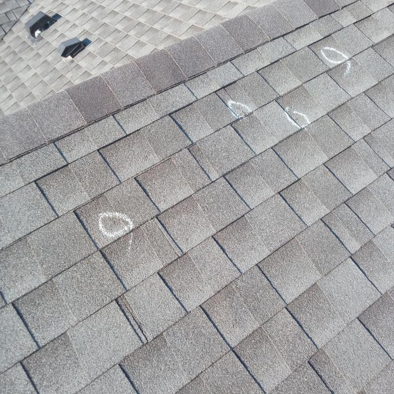 Asphalt roof shingles with hail damage marks Asphalt roof shingles with hail damage marks