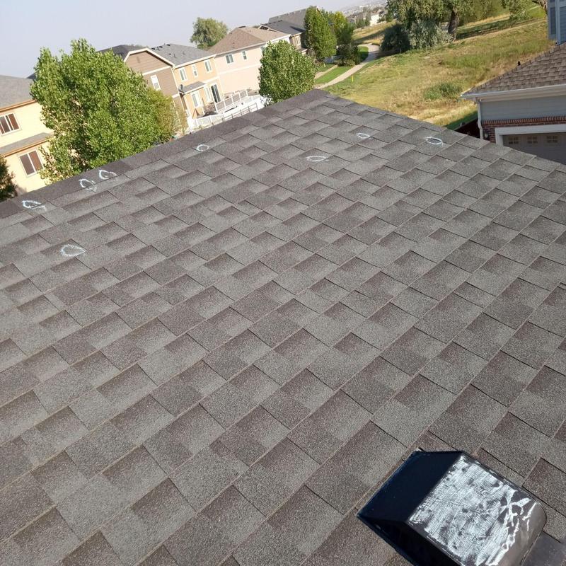 Asphalt shingle roof with marked hail damage spots Asphalt shingle roof with marked hail damage spots