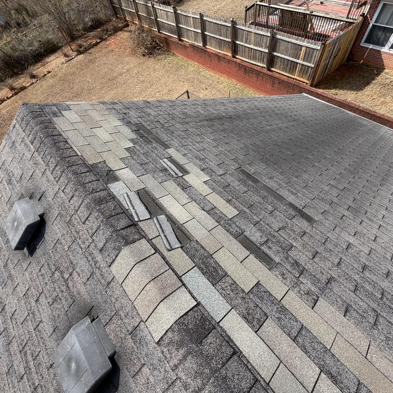 Roof missing shingles and damaged ridge caps