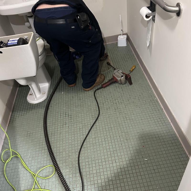 Toilet sewer main line with plumber and tools