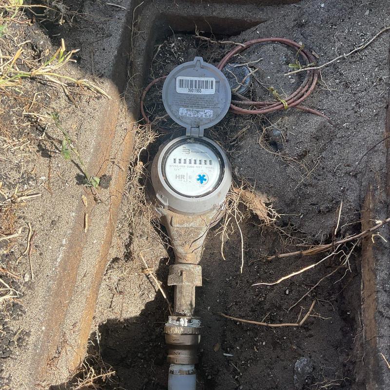 Water meter with connected service line in soil trench