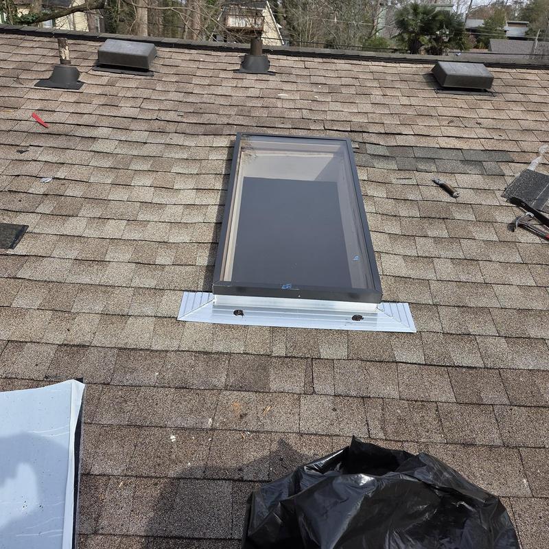 Skylight and roof shingles with new flashing installed