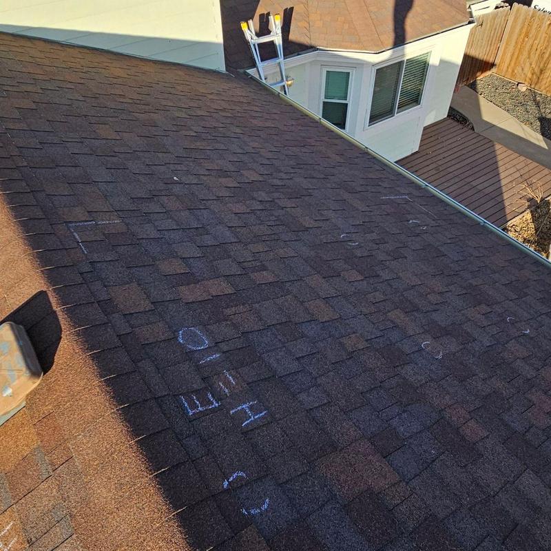 Asphalt shingle roof with marked hail damage spots Asphalt shingle roof with marked hail damage spots