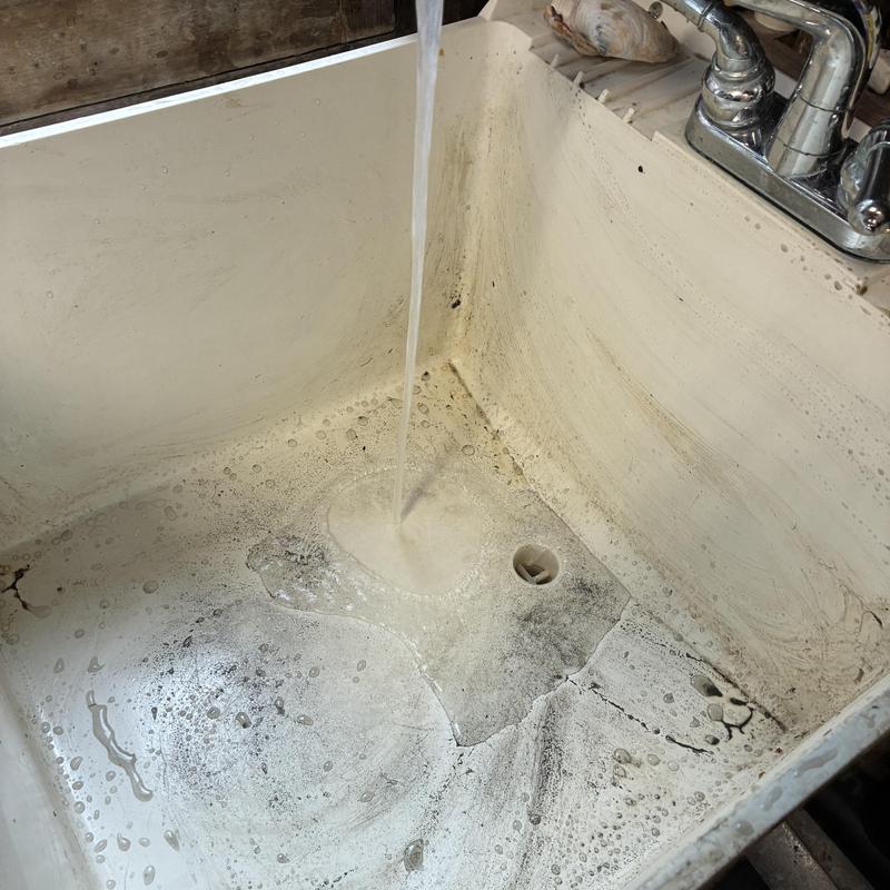 Utility sink draining with running water and drain opening