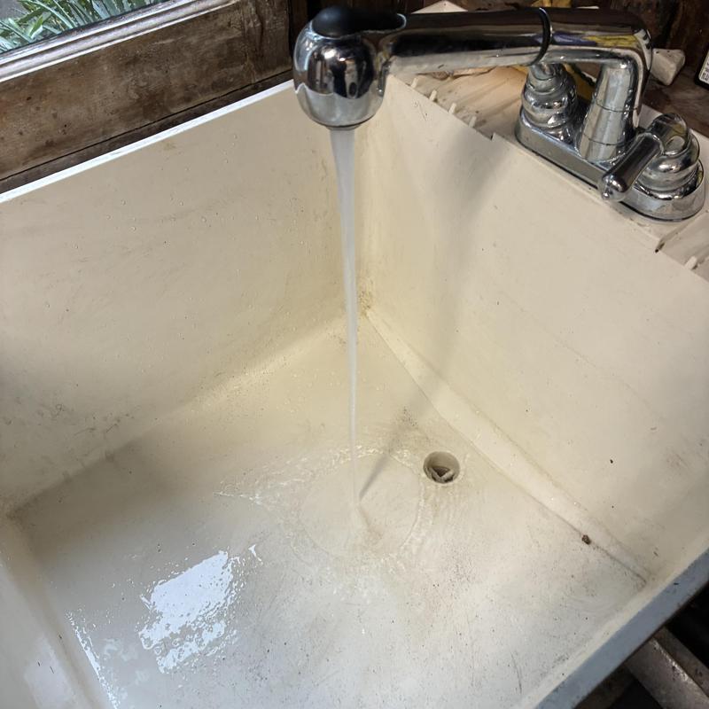 Utility sink with running water and drain hole