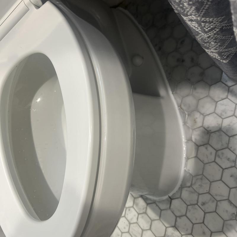 Toilet base with new wax ring and caulked floor