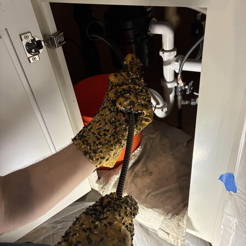 Kitchen sink drain line snaking with protective gloves