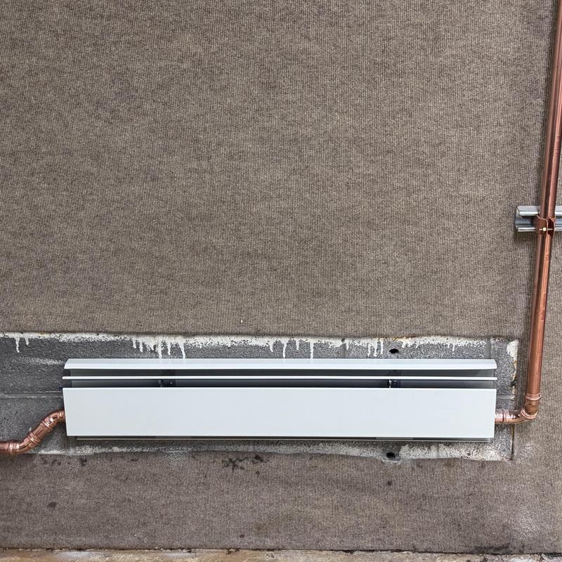 Baseboard heater with rerouted copper piping installation
