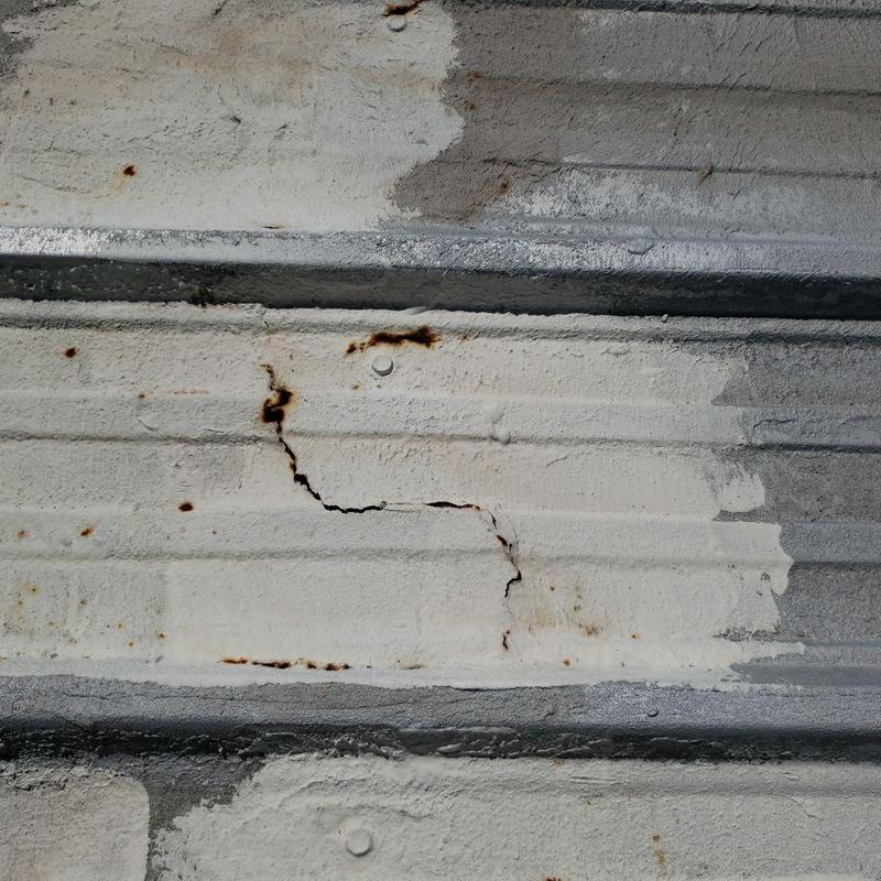 Metal pro-panel roof surface rust and cracks detail Metal pro-panel roof surface rust and cracks detail