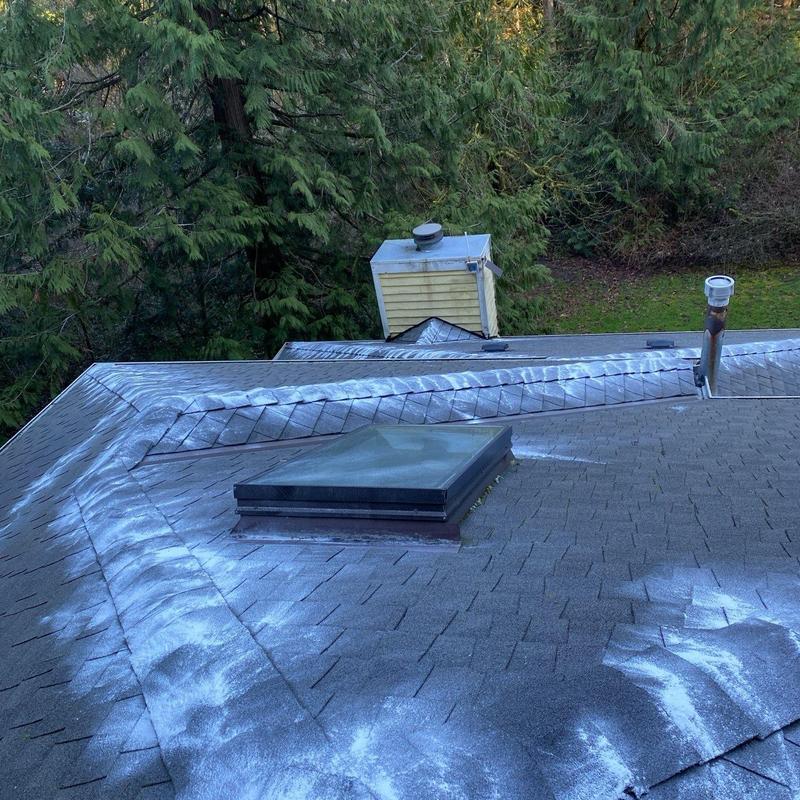 Roof shingles with white sealant applied on seams