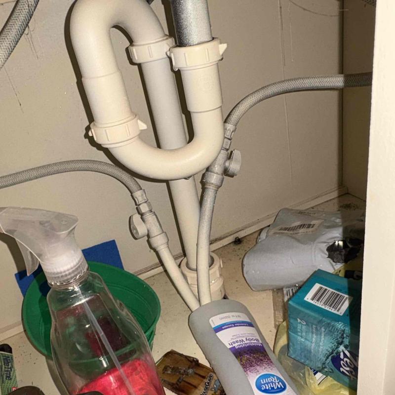 PVC drain pipes and flexible water supply lines under sink