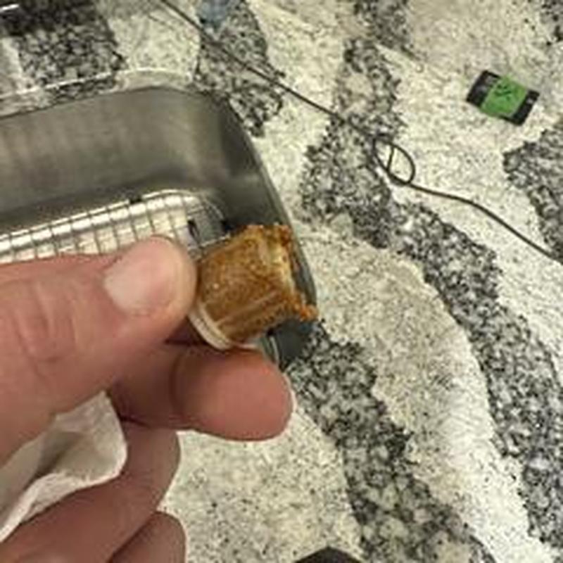 Faucet cartridge clogged with debris removed for inspection