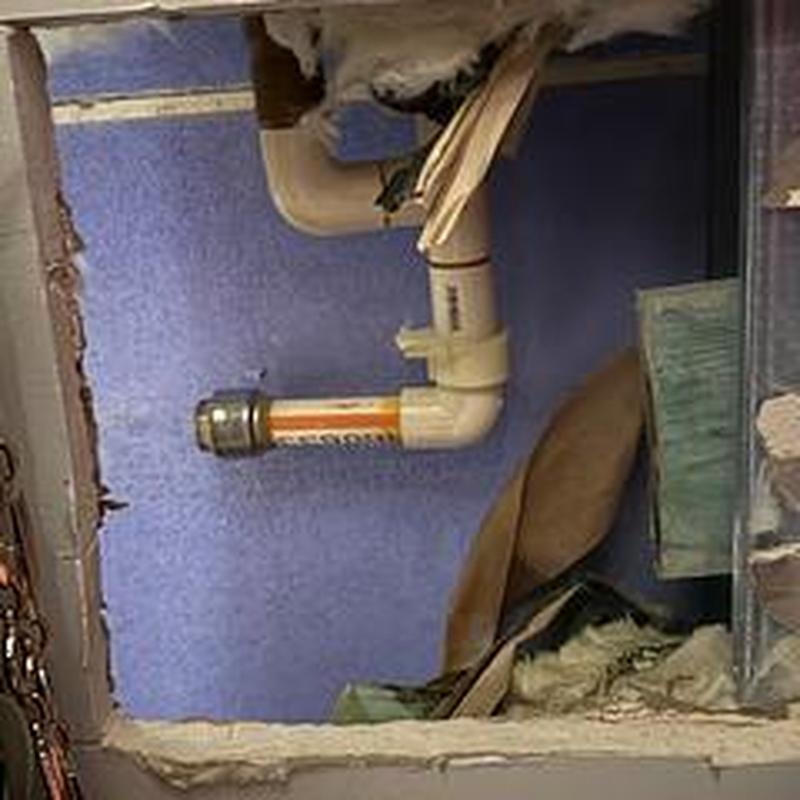 PVC drain pipe installation behind wall cavity in garage