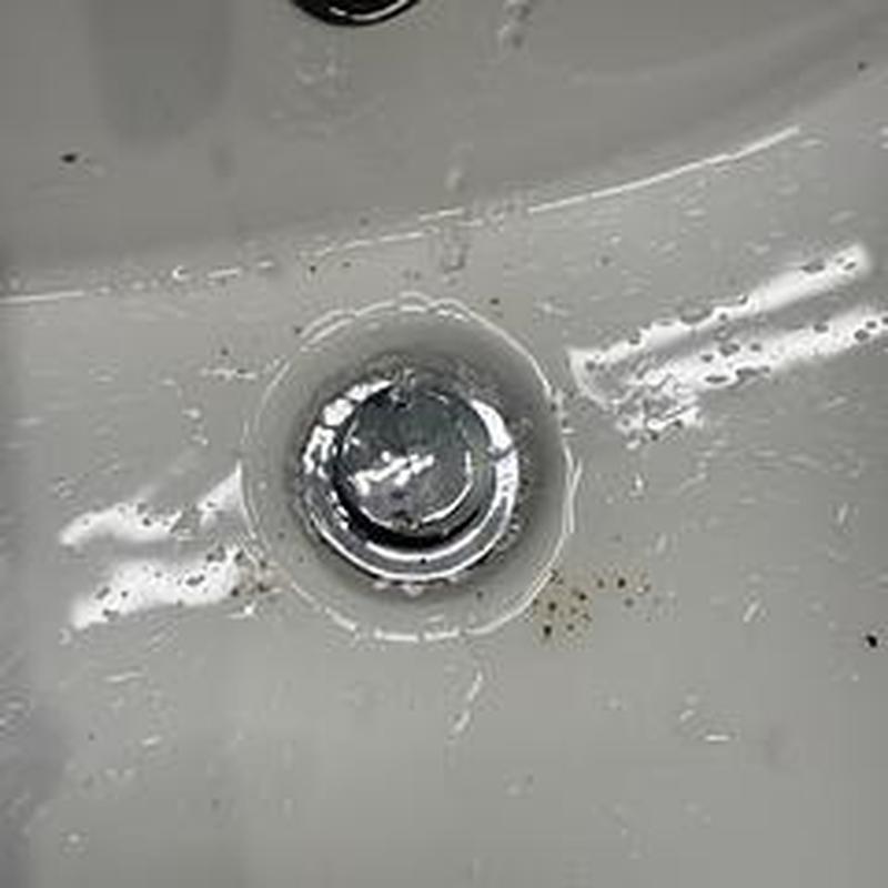Bathroom sink drain with water residue and debris