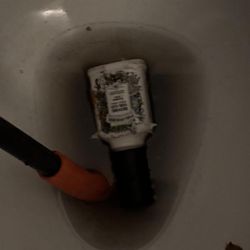 Toilet trap clogged by bottle with auger tool