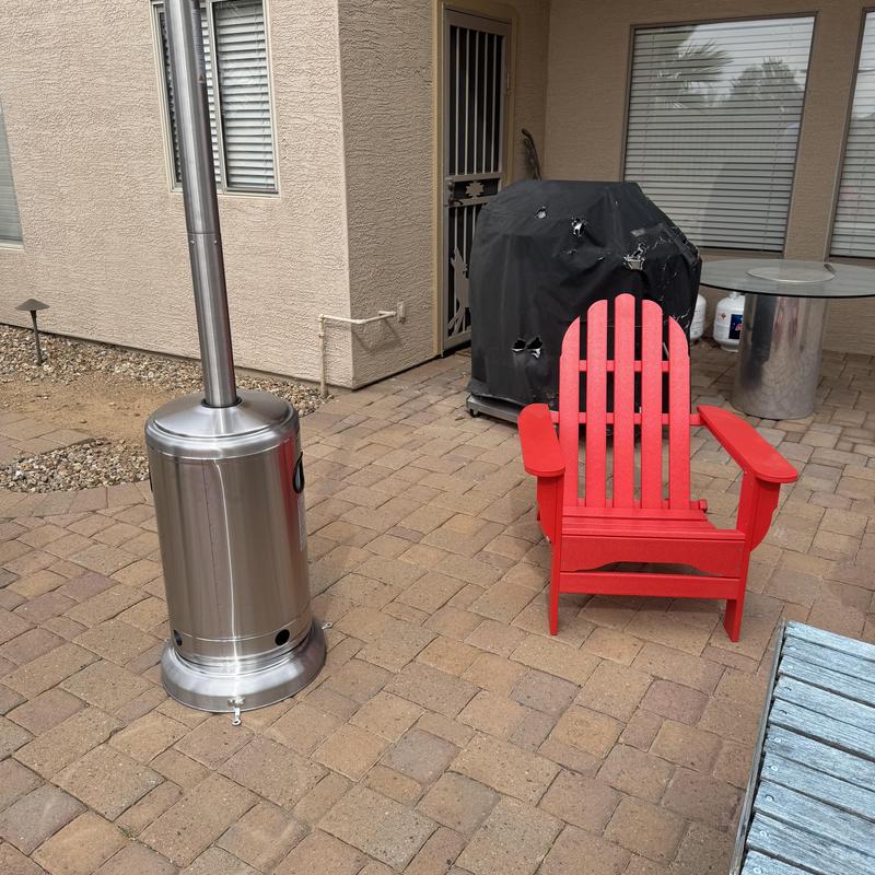 Outdoor patio heater near red chair and covered grill