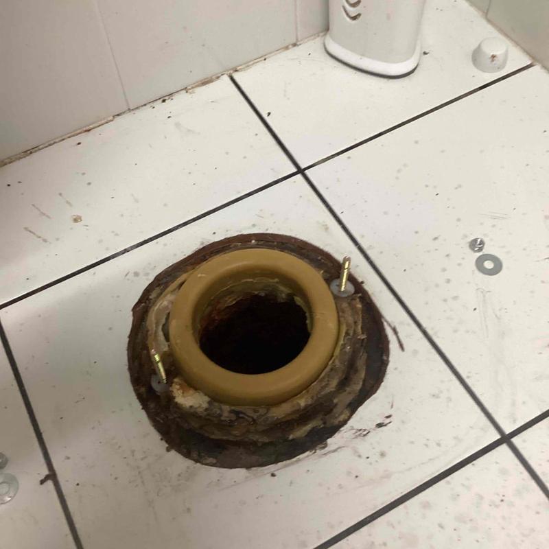 Toilet flange replacement on tiled bathroom floor