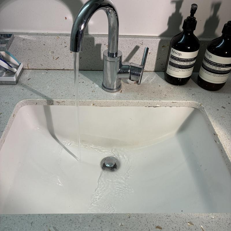 Bathroom sink drain flushing with running water