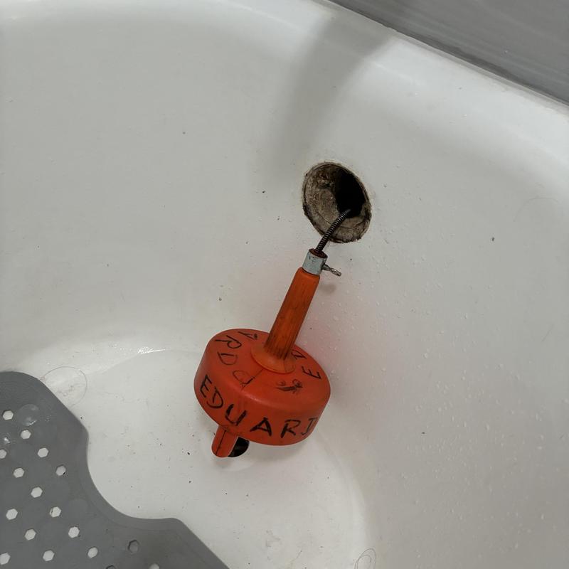 Bathtub drain clog removal with plumbing snake tool