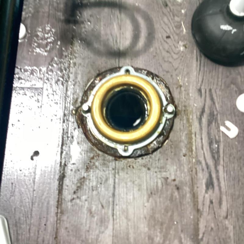 Toilet flange on wooden floor after removal