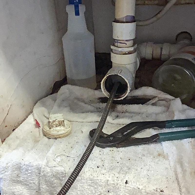 Kitchen sink drain with plumbing snake and wrench