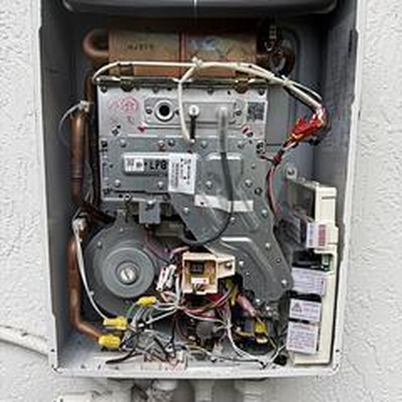 Tankless water heater interior with wiring and piping