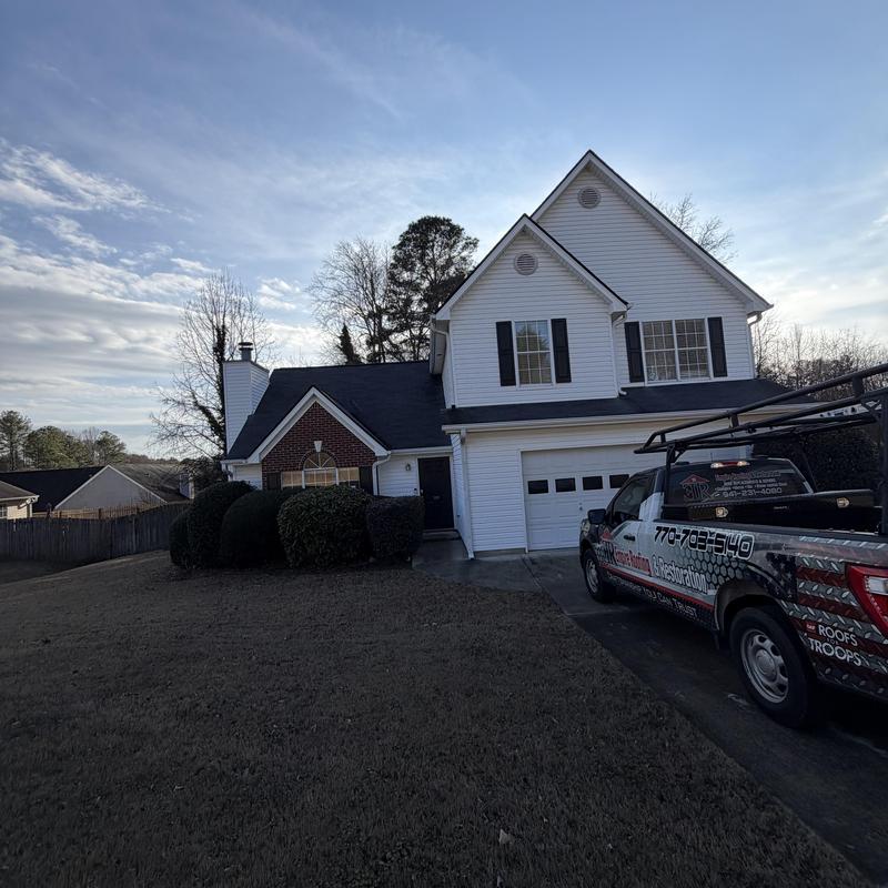 Charcoal 3-tab roof with tarp over missing shingles