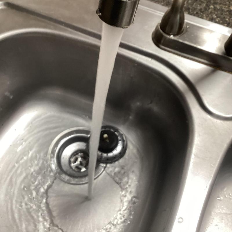 Kitchen sink drain line flowing clear water