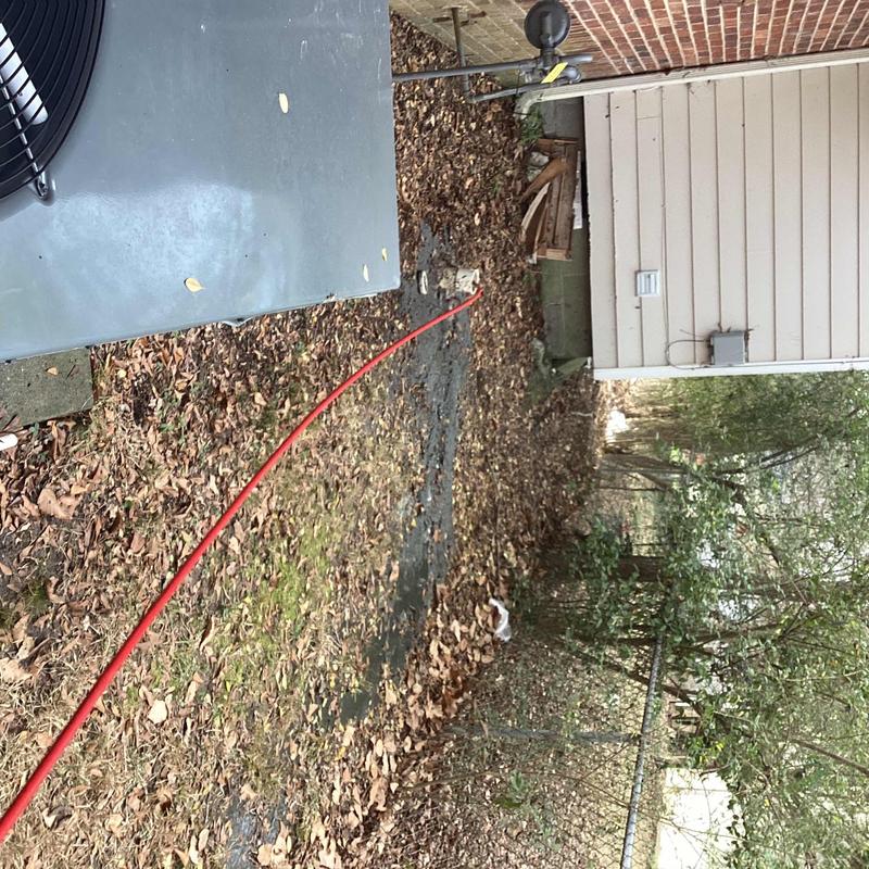 Sewer cleanout with red jetting hose outside house