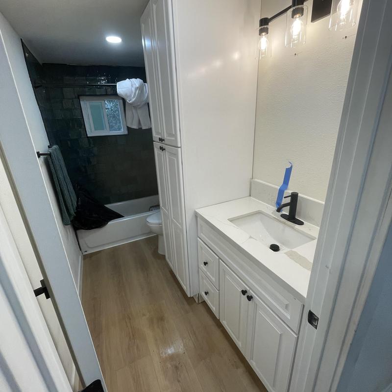 Bathroom vanity and toilet installation with black faucet