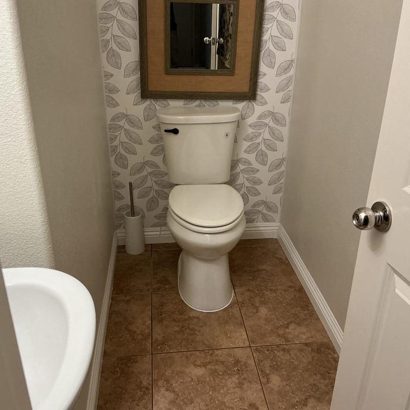 Toilet installation in small bathroom with tile floor