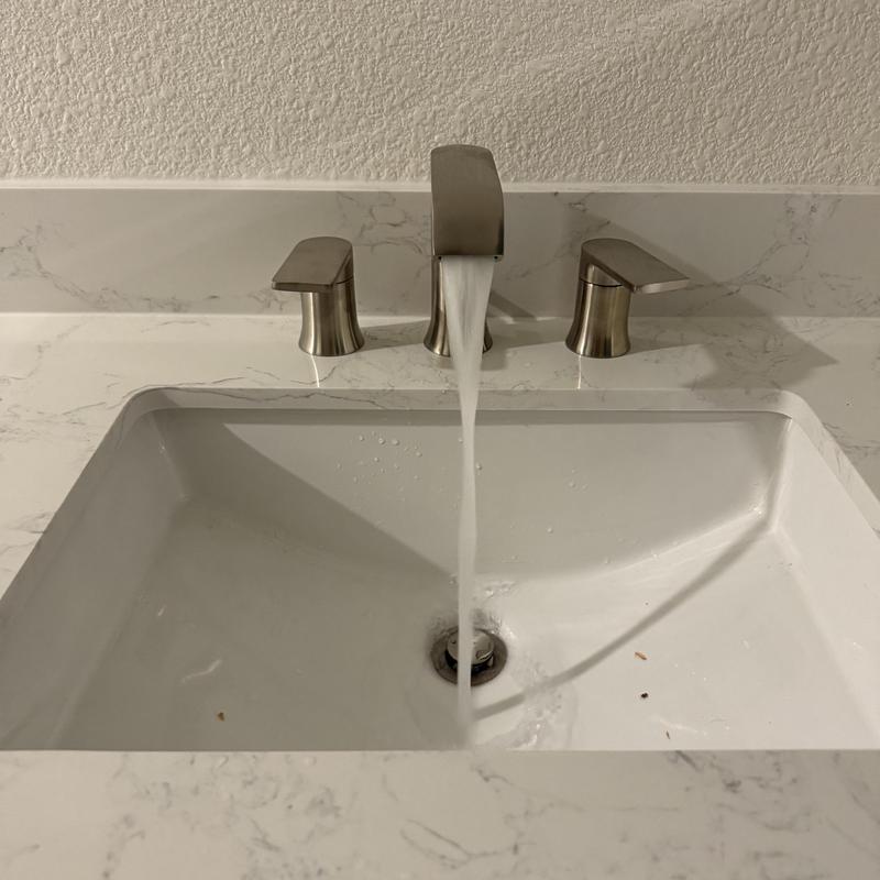 Moen vanity faucet with water flowing in sink