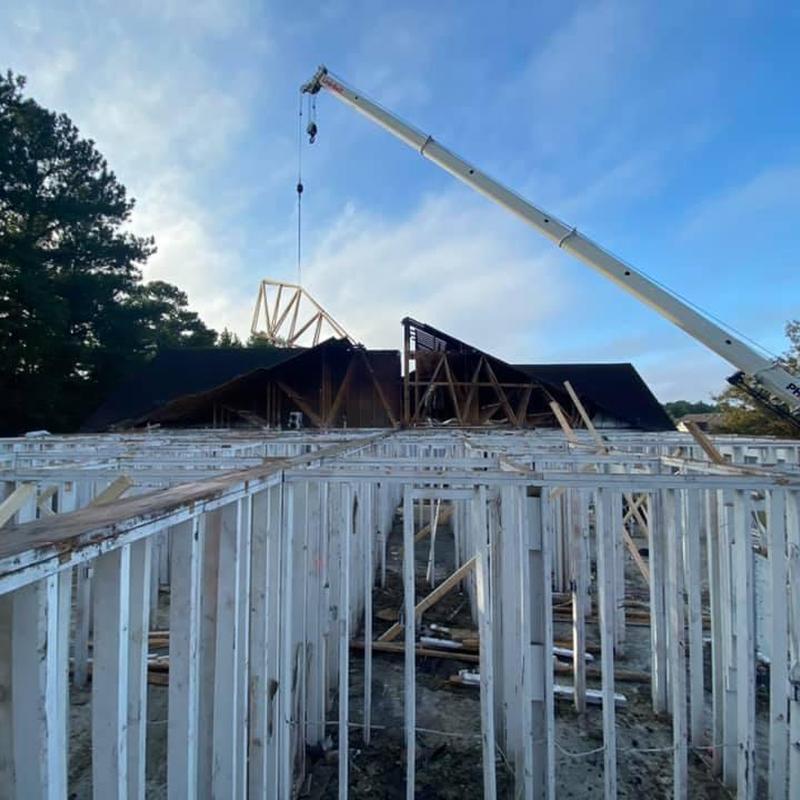 Asphalt shingle roof trusses lifted by crane Asphalt shingle roof trusses lifted by crane