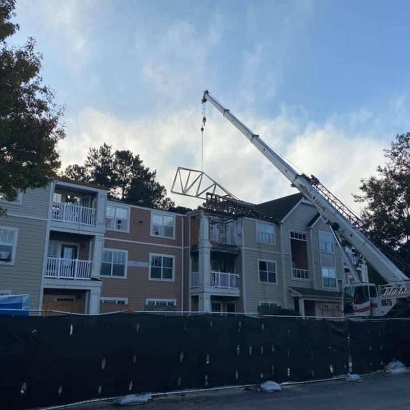 Asphalt shingle roof truss removal with crane at apartment Asphalt shingle roof truss removal with crane at apartment