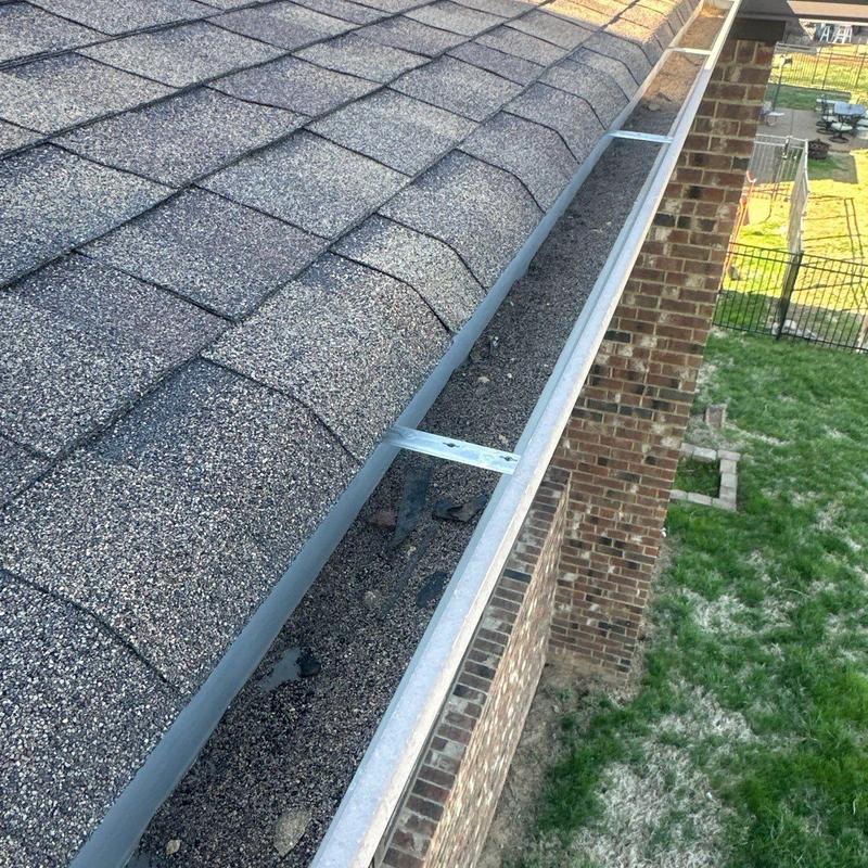 Roof gutter debris buildup and inspection on shingle roof