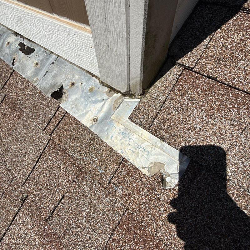Roof flashing with hail damage on asphalt shingles