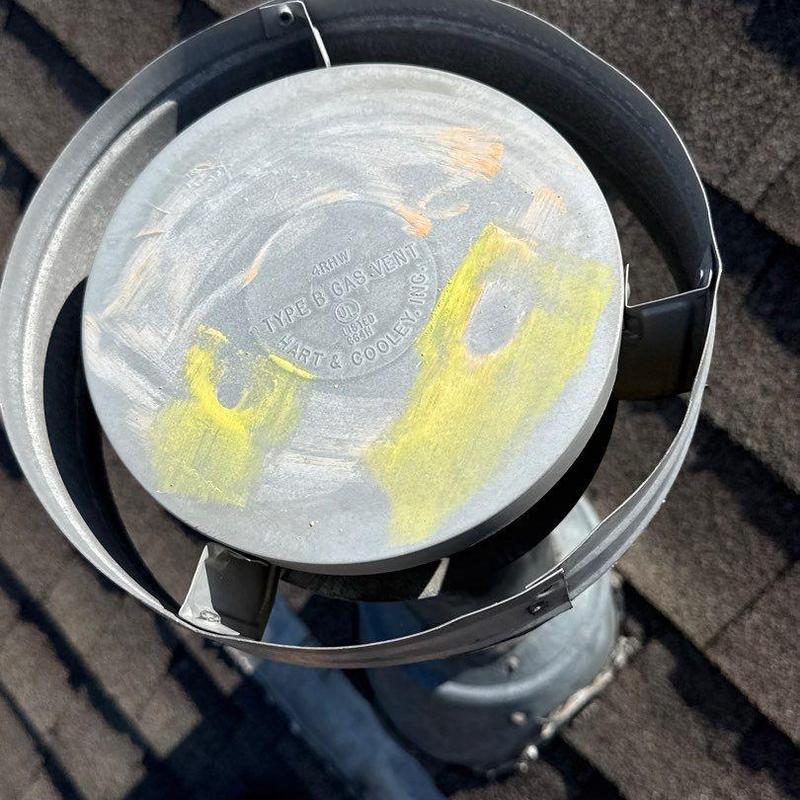 Type B gas vent cap on roof with yellow markings
