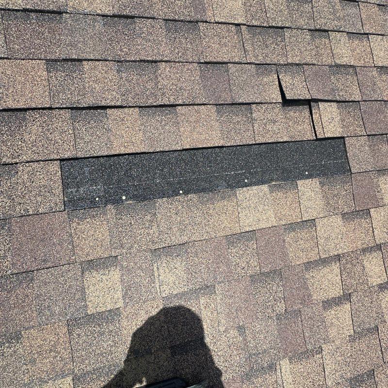 Asphalt roof shingles with lifted and mismatched patch