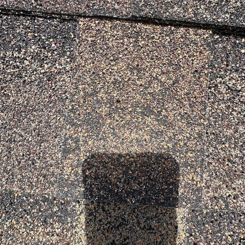 Asphalt shingle granule loss from hail damage close-up