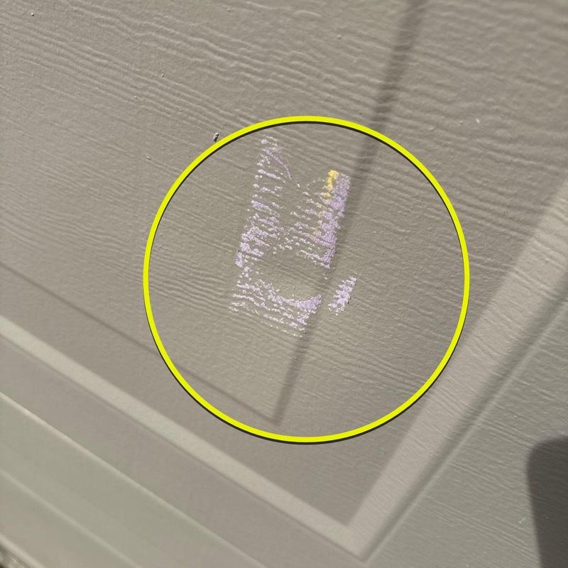 Garage door panel dent marked with chalk circle
