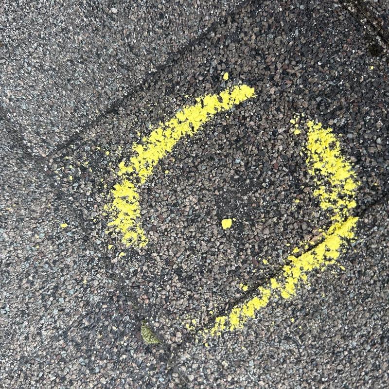 Asphalt shingle hail damage marked by yellow paint