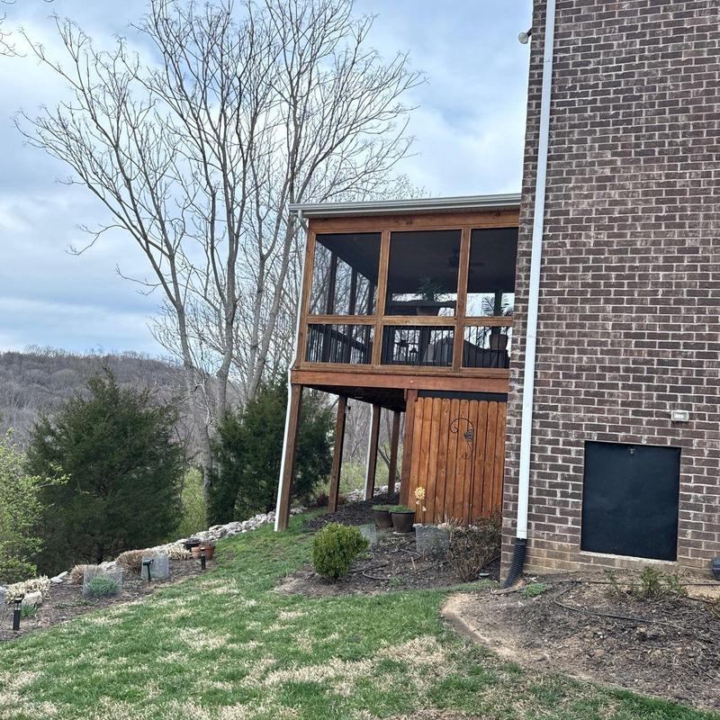 Screened porch structure with wood siding and railing