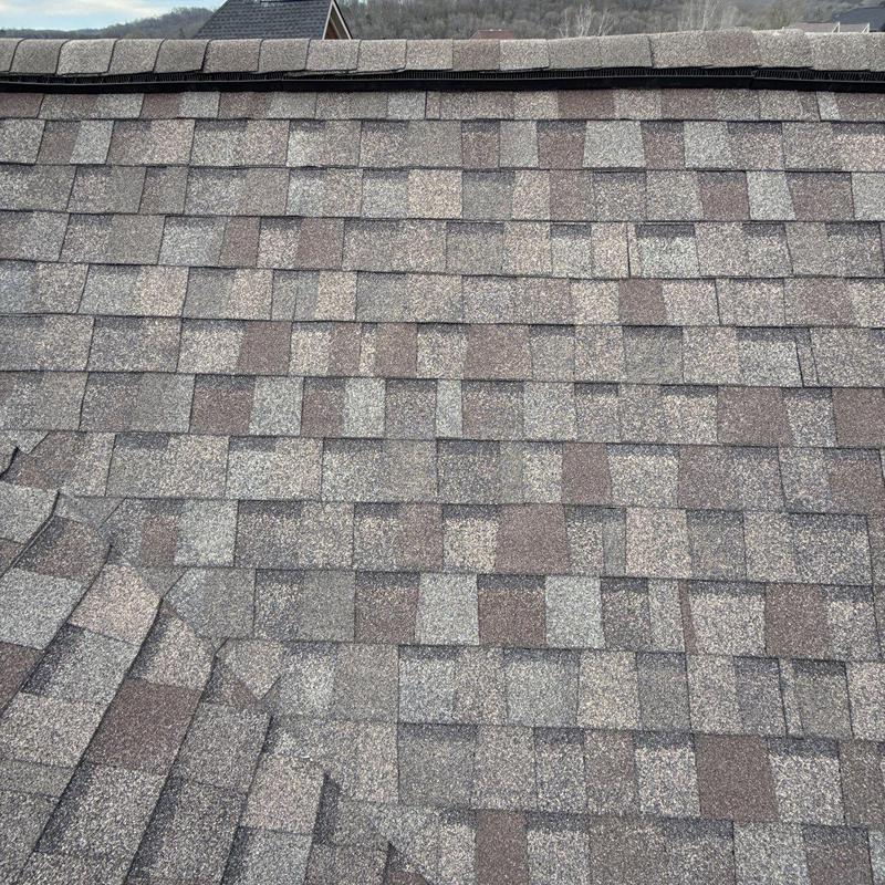 Asphalt shingle roof with hail damage and ventilation strip