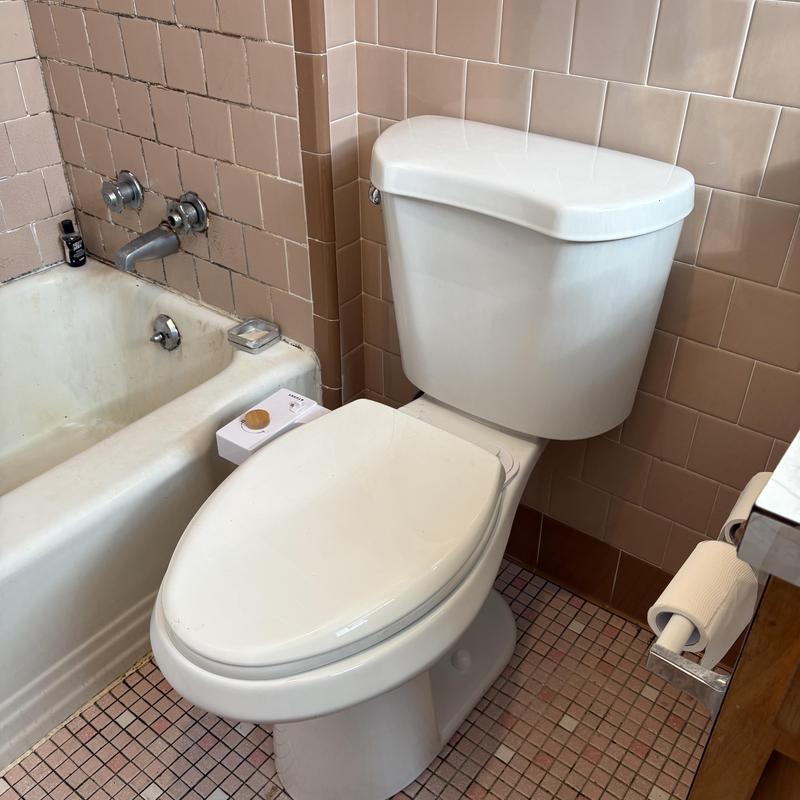 Toilet and bathtub plumbing with tiled walls and floor Toilet and bathtub plumbing with tiled walls and floor