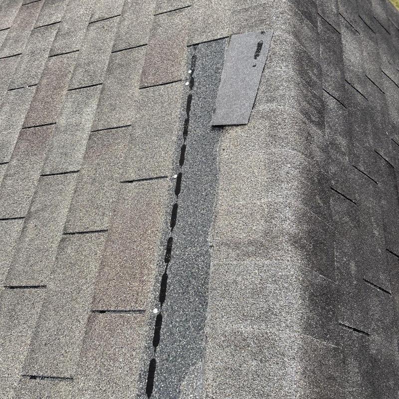 Asphalt shingle ridge with exposed fasteners and wear