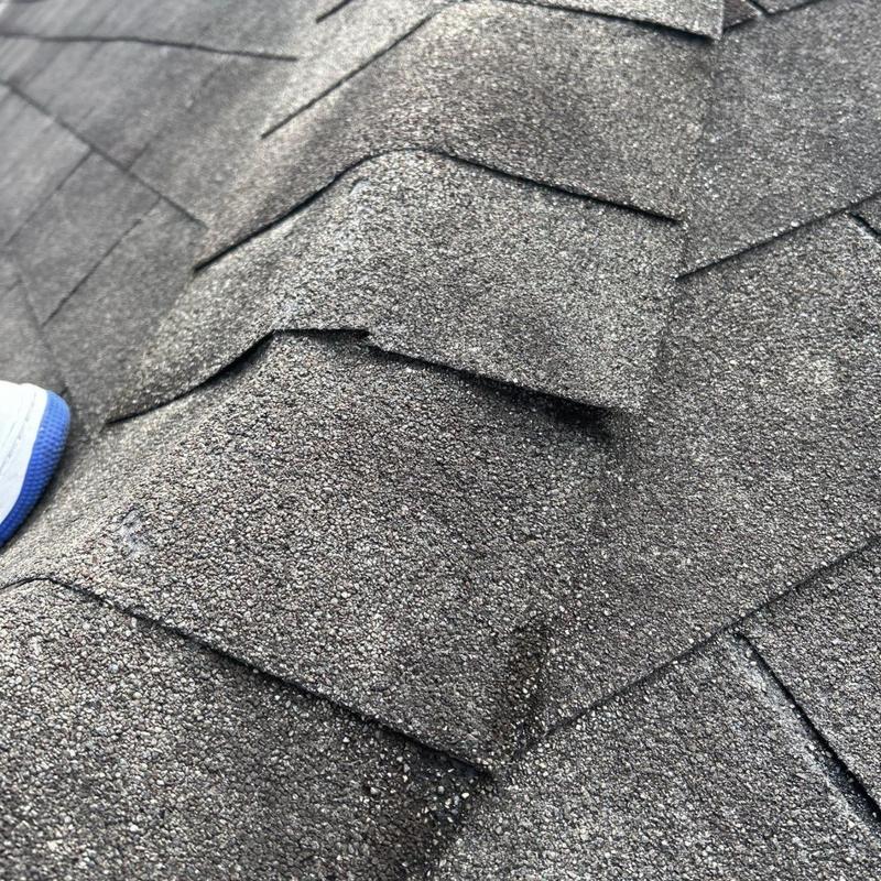 Asphalt shingle roof ridge with minor wear inspection