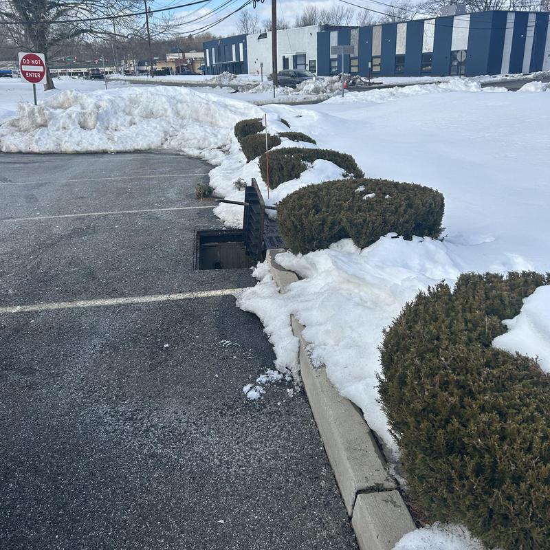 Storm drain cleaning with snow around in parking lot Storm drain cleaning with snow around in parking lot