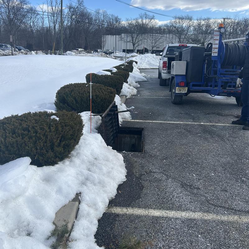 Sewer jetting with jetter truck in snowy parking lot Sewer jetting with jetter truck in snowy parking lot