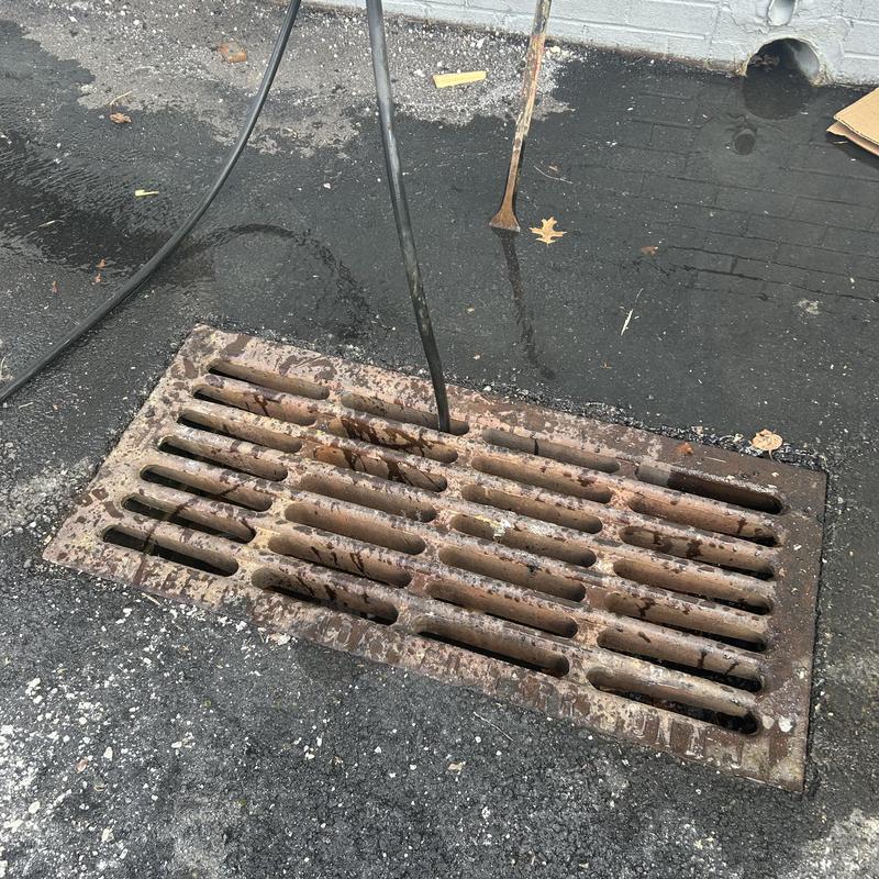 Storm drain jetting hose inserted in drain grate Storm drain jetting hose inserted in drain grate