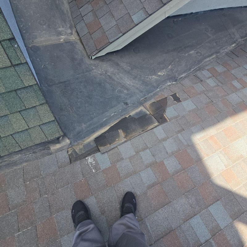 Shingle roof with damaged and dislodged shingles near EPDM roof Shingle roof with damaged and dislodged shingles near EPDM roof